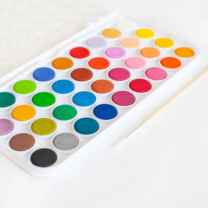 Open watercolor paint set with rows of bright colors