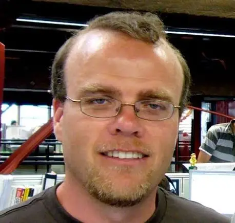 Portrait of Rasmus Lerdorf before a Web page combining HTML, PHP, and database access