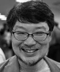 Portrait of Yukihiro Matsumoto before Ruby code highlighting objects and blocks
